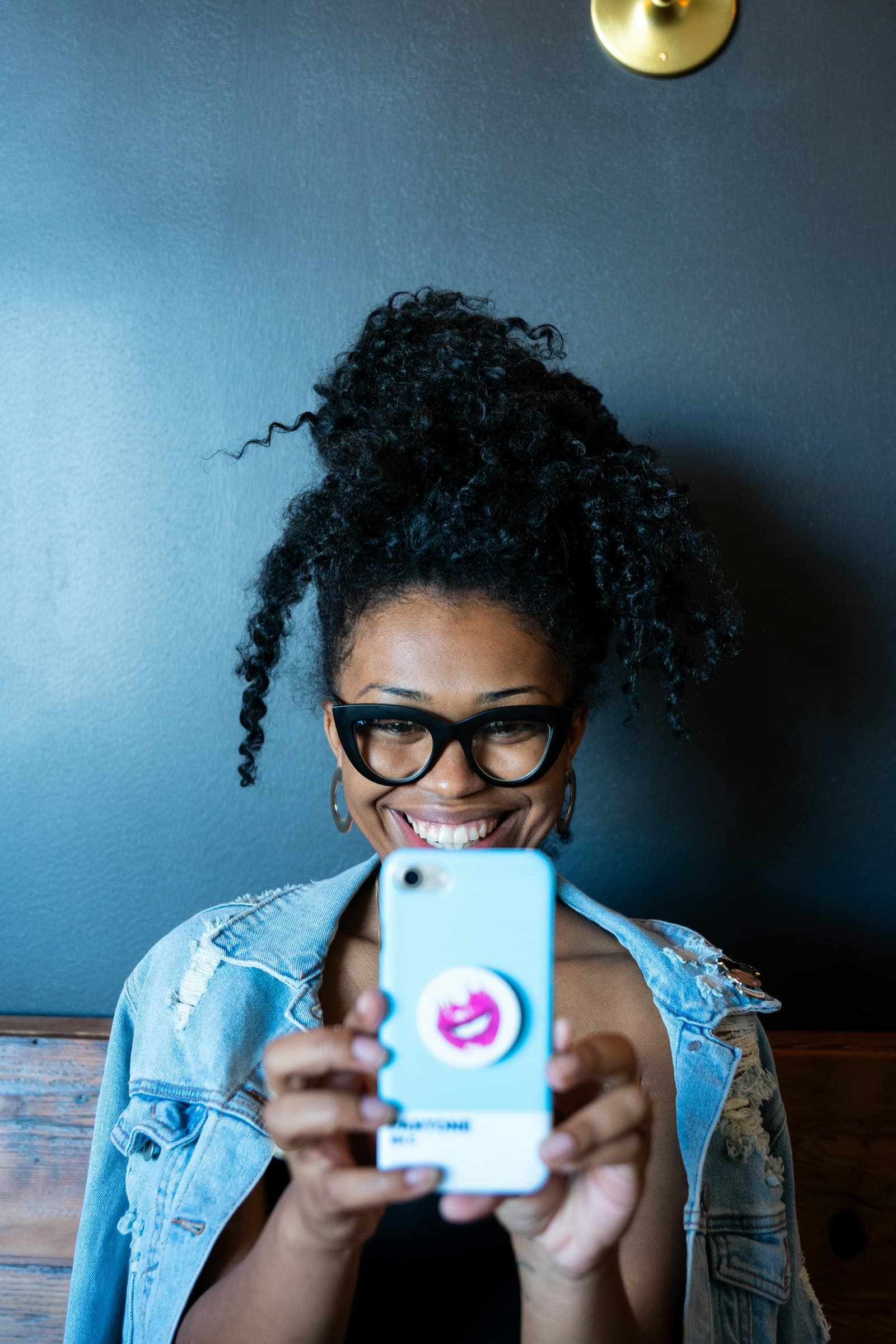 A smiling resident holding up her phone